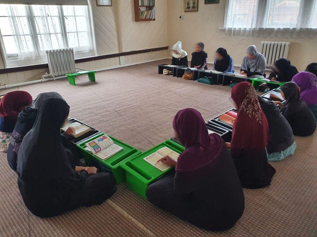 Girls reading Qur'an together on the carpet