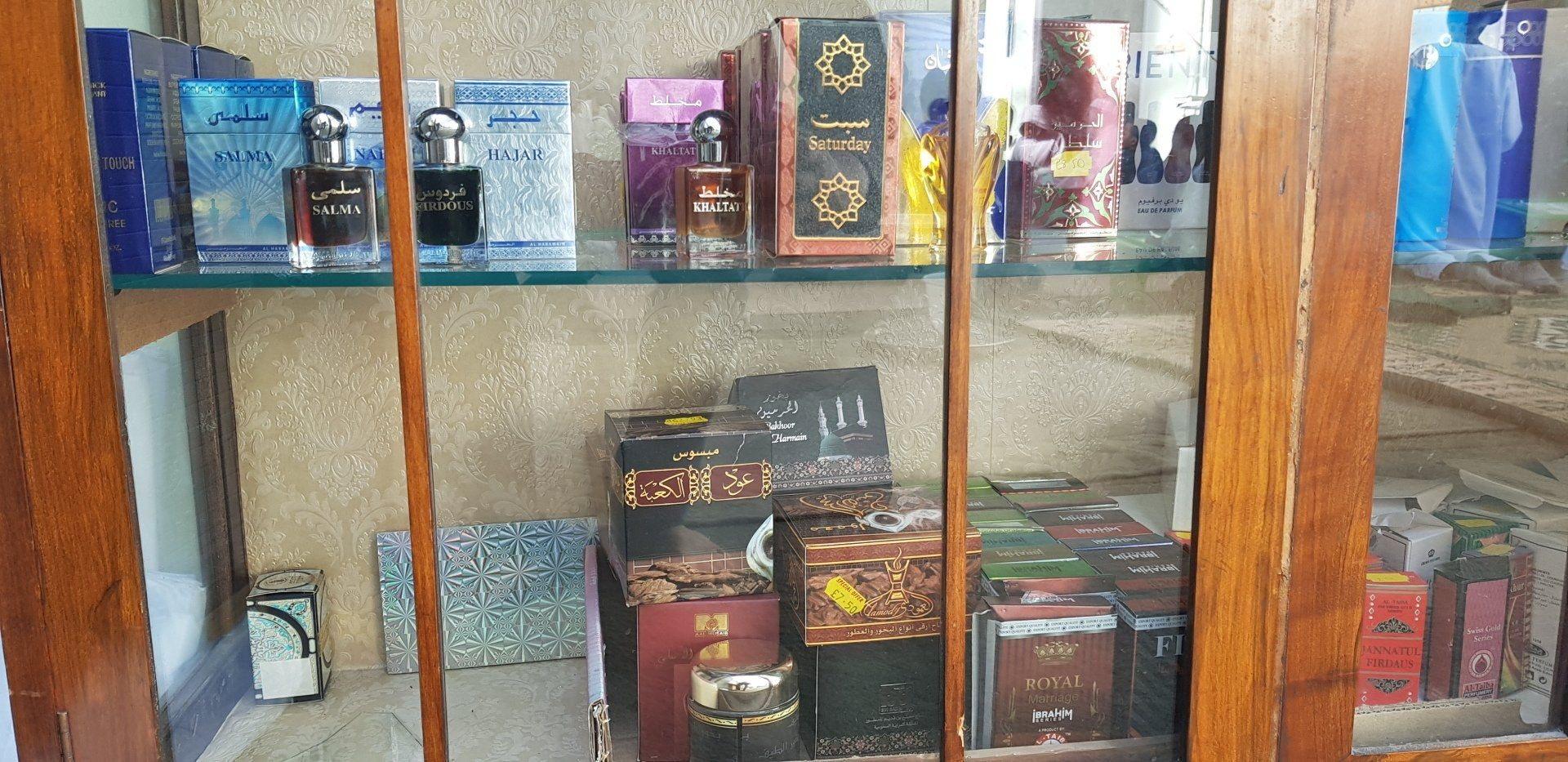 A glass cabinet in the masjid shop stocked with attars and boxed perfumes